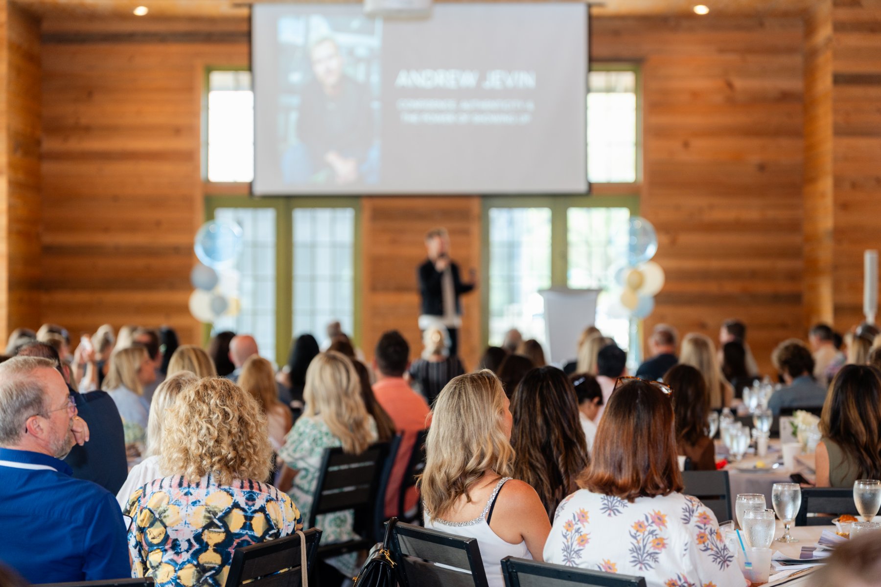 A speaker on stage in front of a full room at the summit
