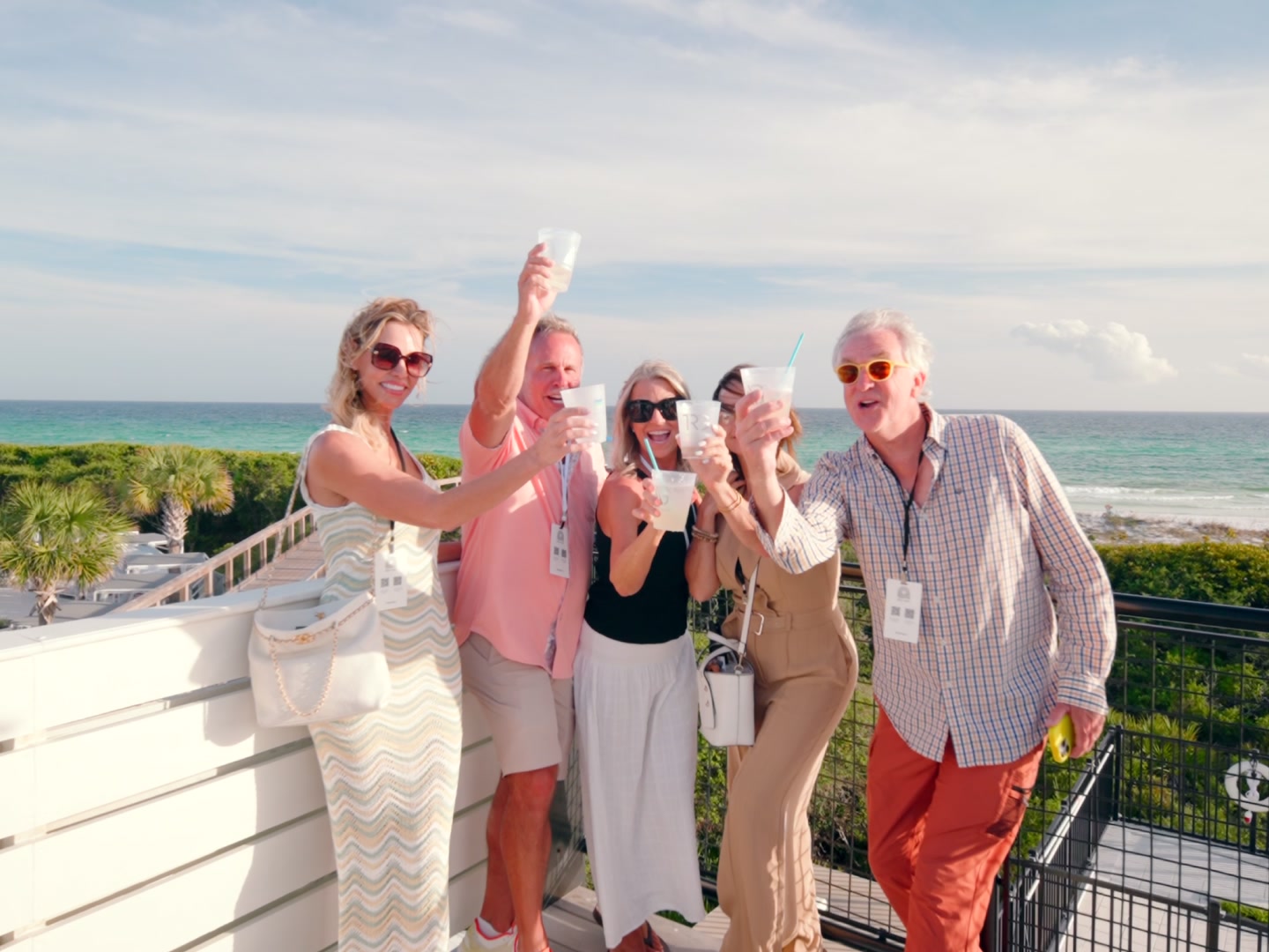 Attendees raising a toast on a rooftop above the Gulf